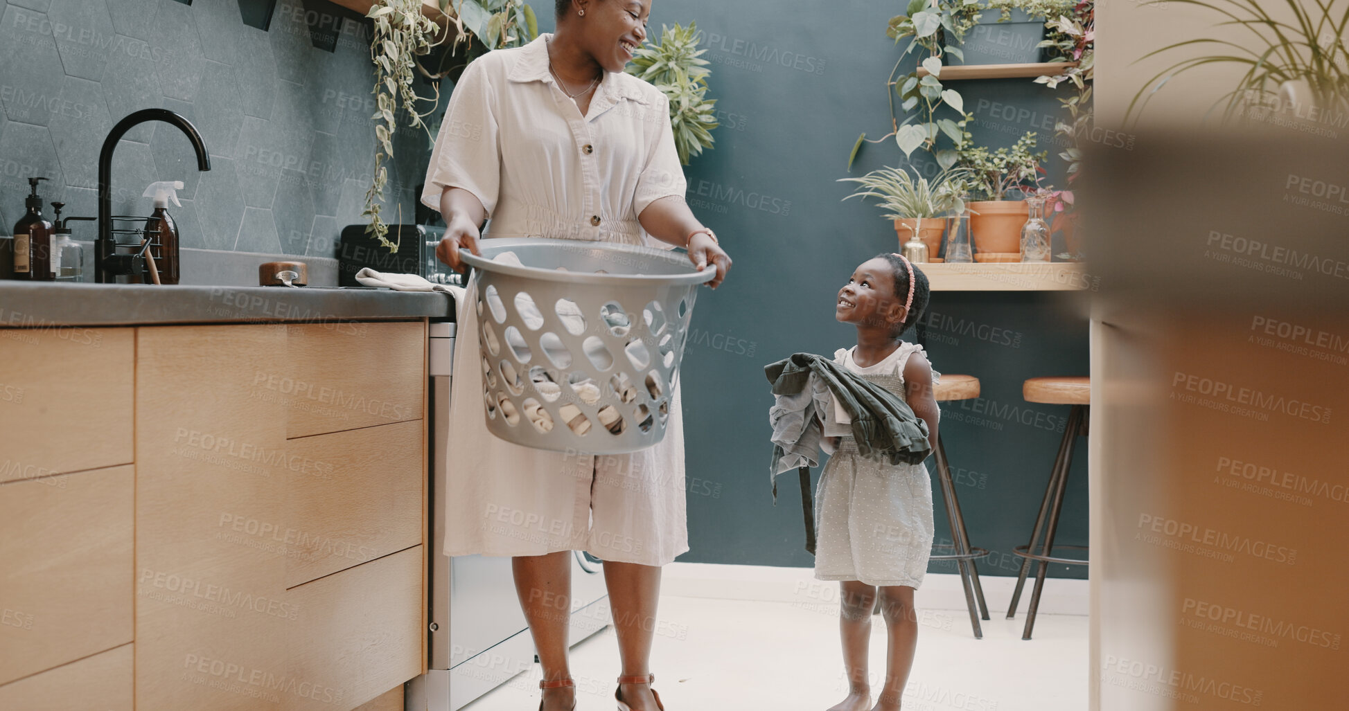 Buy stock photo Helping mother and child with laundry, basket and cleaning clothes in family home, kitchen or house. Happy, girl and excited for learning with mom or maid to clean with washing machine in apartment