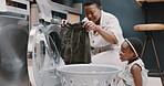 Laundry, mother and child helping with folding of clothes together in a house. Happy, excited and young girl giving help to her mom while cleaning clothing from a washing machine in their home