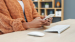 Women using a phone to type a text while working as a web developer for a startup company in an office at work. One designer browsing the internet and using social media while sitting at a desk