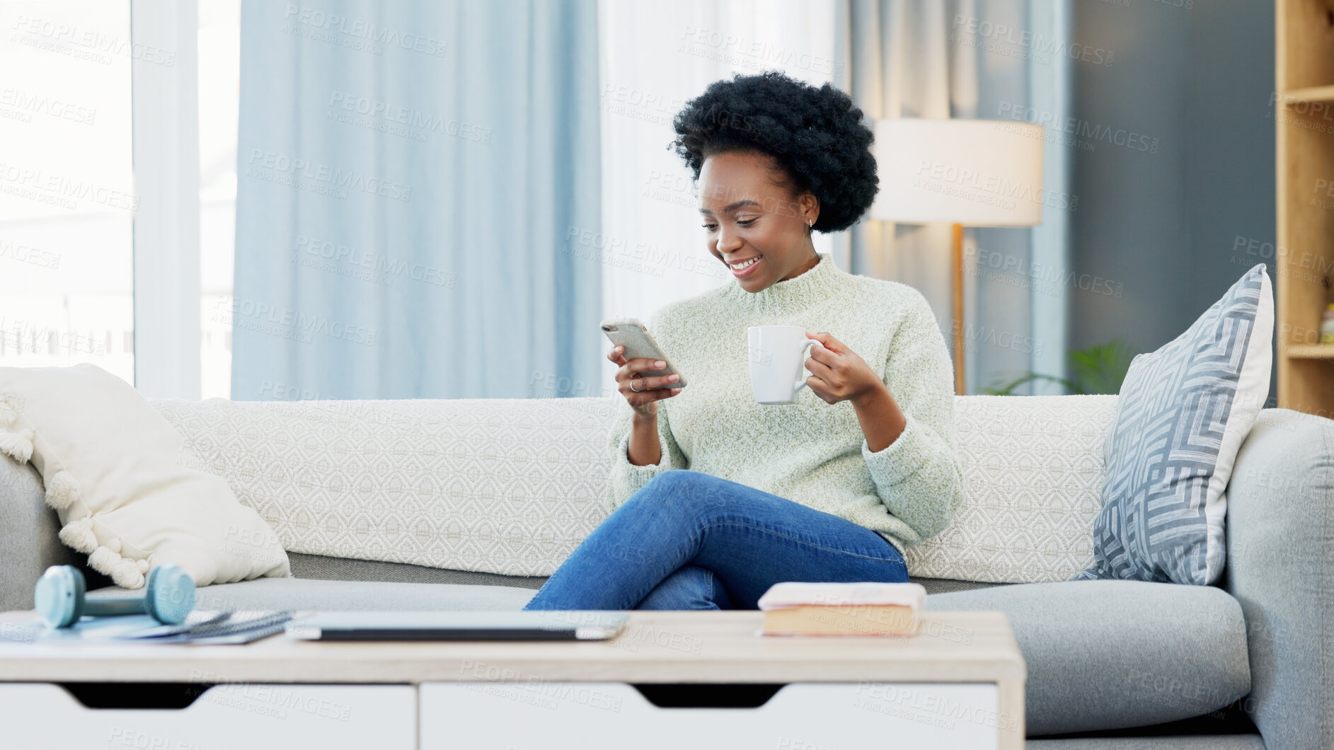 Buy stock photo Black woman, texting and phone on sofa, drinking coffee and home. Smiling, browsing social media and laughing while enjoying alone time, house and reading sms with tea, living room and comfortable