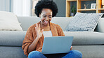 Happy African American woman using laptop and waving on a video call in a living room. Young black female having a casual chat with friends at home. Lady excited to talk to her family during lockdown