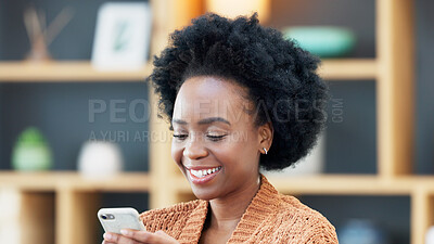 Young woman smiling and laughing while texting on a phone at home. Cheerful female chatting to her friends on social media, browsing online and watching funny internet memes while relaxing in leisure