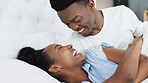 Happy black couple in bedroom kiss and smile for love, romance and intimacy at house or home in morning. Young, happiness and kissing black woman and man or romantic black people dating bond together