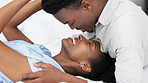 Black man and black woman couple kiss. Young, in love and African American people in relationship saying I love you. Kissing, romantic and smiling face to face in bed together at home, intimacy