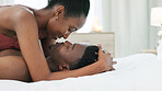 Couple in bedroom, kiss and saying I love you in bed at home. Black, young and romantic man and woman in relationship sharing intimate moment together. Happy, affectionate and loving black couple