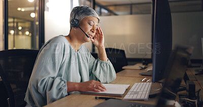 Night, call center or senior woman tired, exhausted or burnout in workplace, overworked or stress. Dark, female employee or consultant with headset, late night or customer service agent with headache