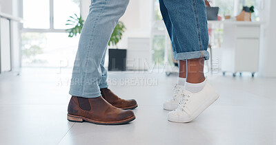 Closeup, shoes and couple in tiptoe moment, romance and sweet relationship in their home. Feet, love and man with woman embracing, leaning and sharing intimate, embrace and romantic in living room