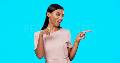 Buy stock photo Advertising studio smile, woman and pointing at ads commercial, retail store promotion or mockup announcement. Sales info space, direction and Indian brand ambassador presentation on blue background