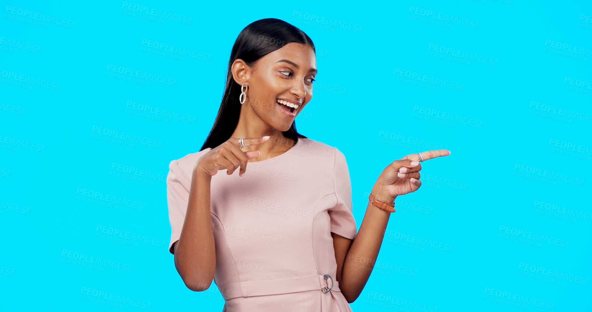 Buy stock photo Advertising studio smile, woman and pointing at ads commercial, retail store promotion or mockup announcement. Sales info space, direction and Indian brand ambassador presentation on blue background