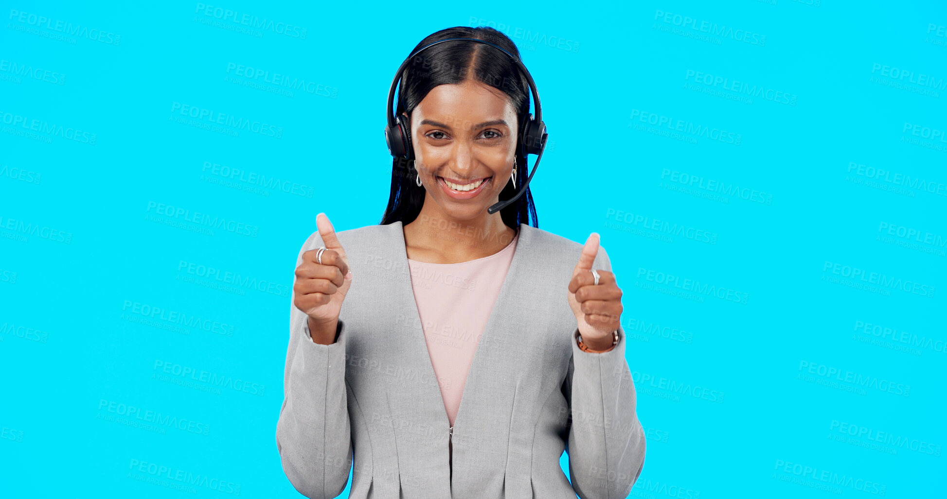 Buy stock photo Call center, thumbs up and portrait of Indian woman in studio blue background for communication. Customer support, telemarketing and person with emoji for crm service, help and agreement or approve