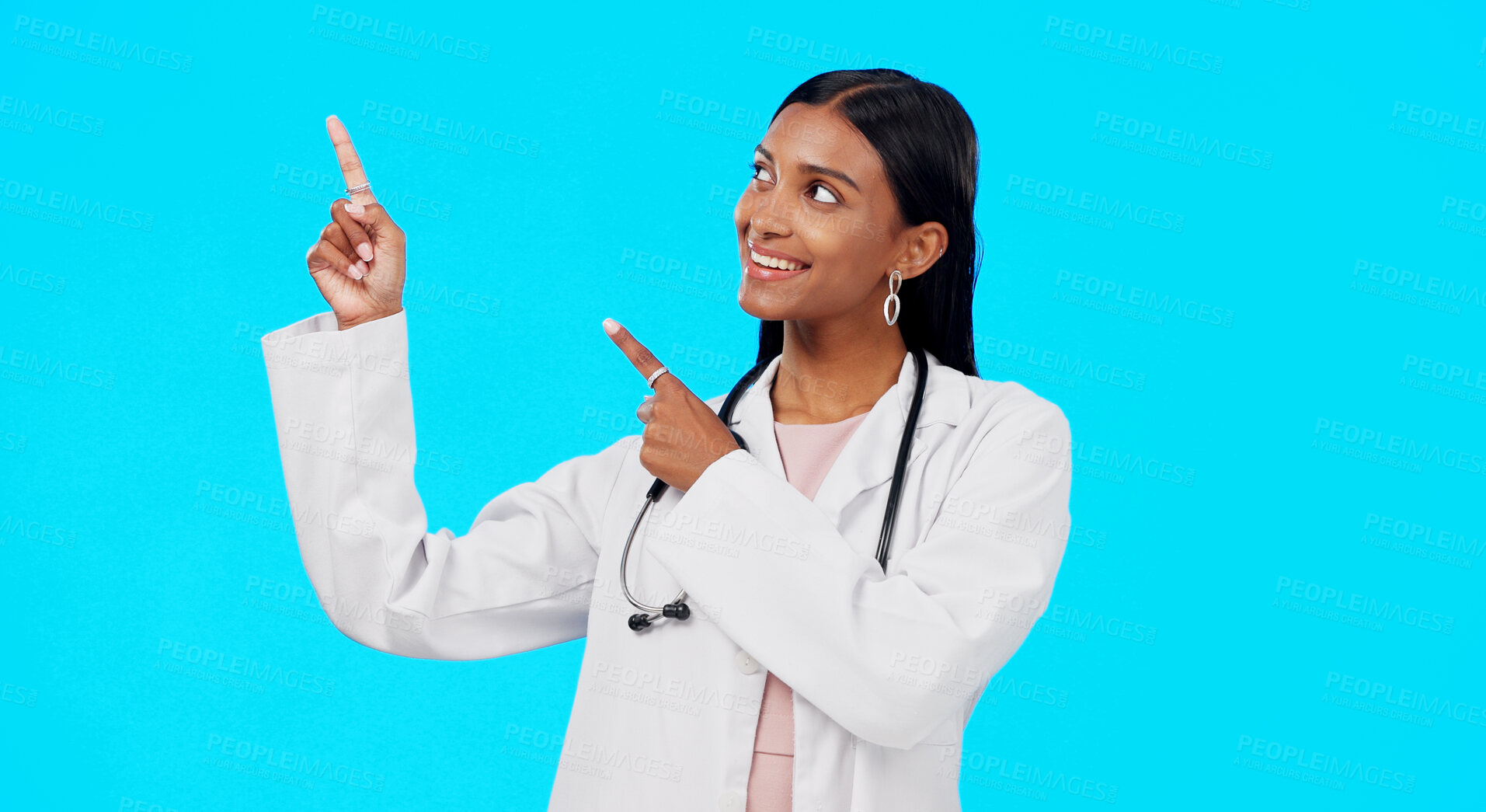 Buy stock photo Studio doctor, happiness and woman point at medical info, hospital direction or clinic service promotion, offer or notification. Medicine announcement, brand logo and pharmacist on blue background