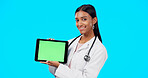 Tablet, green screen and doctor face isolated on blue background telehealth, medical or service software app. Healthcare professional or indian person on digital technology, studio and mockup space