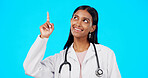 Healthcare doctor, smile and woman point at medical promotion, hospital notification or clinic announcement mockup. Nurse portrait, studio advertising surgeon and marketing female on blue background