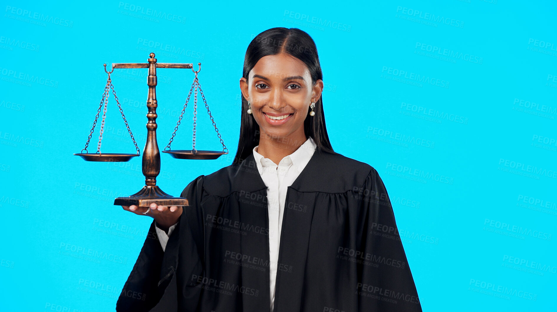 Buy stock photo Portrait, justice and scale with a woman judge in studio on a blue background for law or legal case. Smile, balance and a happy young indian advocate looking confident with her verdict on a trial