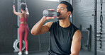 Man, tired and drinking water in gym workout, training and exercise break for energy recovery and muscle rest. Personal trainer, fitness coach and drink for wellness, sports health and weight loss