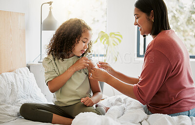 Buy stock photo Loving mother comforting her daughter with a bandage in bed, being affectionate and caring at home. Young parent helping her sick child, applying a plaster and bonding, special moments of motherhood