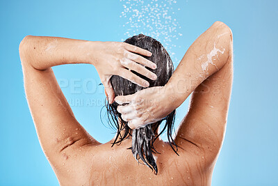 Buy stock photo Hair, wash and woman in shower with water for haircare, cleaning and health on a blue studio background. Bathroom, cleansing and hygiene for hair grooming with shampoo or soap while showering 