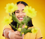 Happy, portrait and a woman showing flowers isolated on a yellow background in a studio. Floral, spring and a girl giving a bouquet as a present, sharing plants and fresh flower with a smile