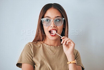 Buy stock photo Thinking, face and woman with lollipop, glasses and confidence against a white studio background. Female, sweet and person with funky eyewear, candy and wonder with thoughts, daydreaming and decision
