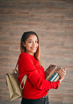 Portrait, books and education with a student woman on a wooden background for learning at college or university. School, study and scholarship with an attractive young female pupil wearing a backpack