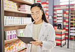 Pharmacist, tablet and Asian woman in pharmacy for healthcare or online consultation in drugstore. Telehealth, technology and happy person or medical professional with touchscreen for shop research.