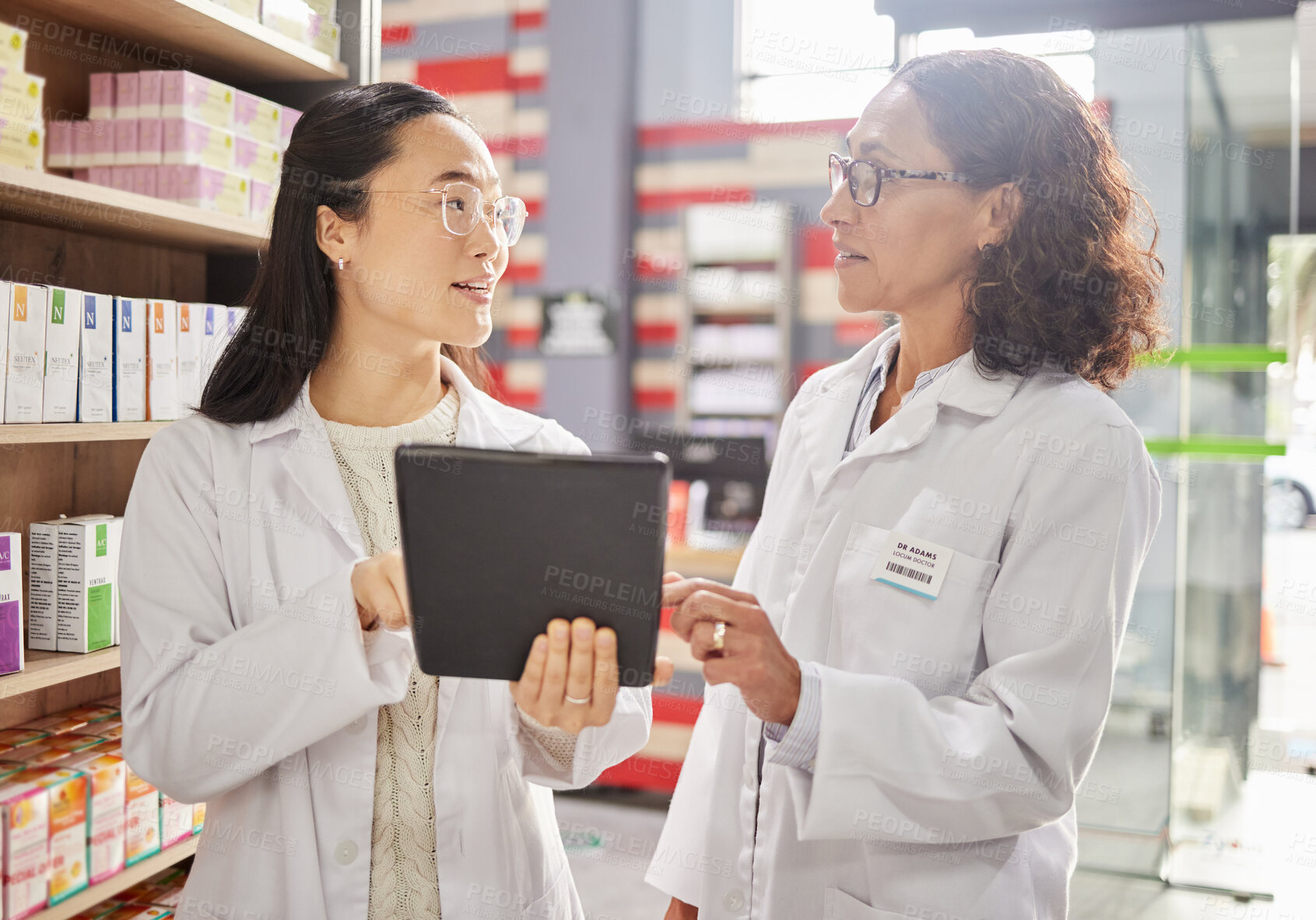 Buy stock photo Pharmacy, tablet and stock with women in a dispensary talking about prescription medicine for an online order. Healthcare, technology or diversity with a female pharmacist team working in a drugstore