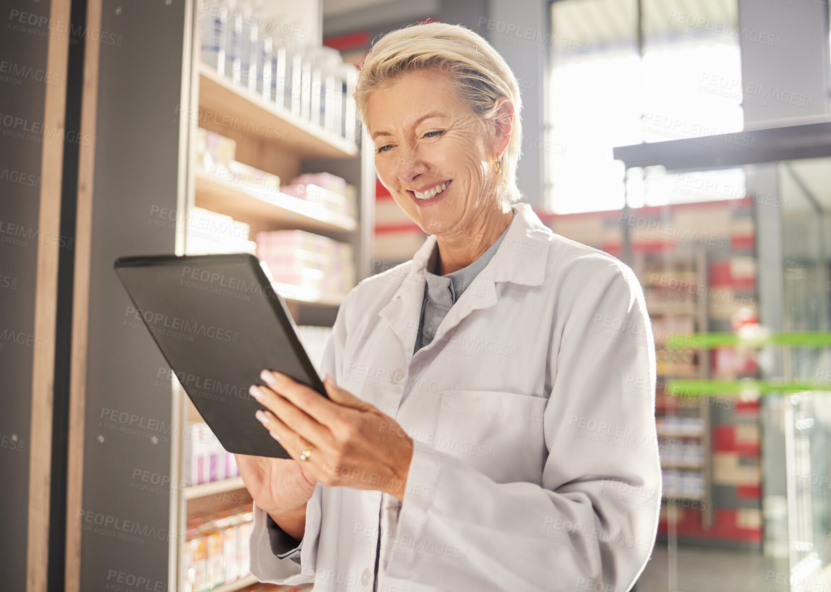 Buy stock photo Doctor, woman and tablet in pharmacy for research, healthcare or checking stock and inventory at supermarket. Happy senior female medical pharmacist smiling on touchscreen for results at retail store