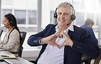 Portrait, heart hands or mature happy man in call center with smile excited about customer care services in office. Sales, communication or friendly senior consultant with love sign at crm business