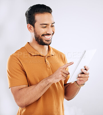 Buy stock photo Man, tablet and smile in studio on social media, reading ebook and online website on white background. Happy male model, digital technology and connection for networking, search internet and download