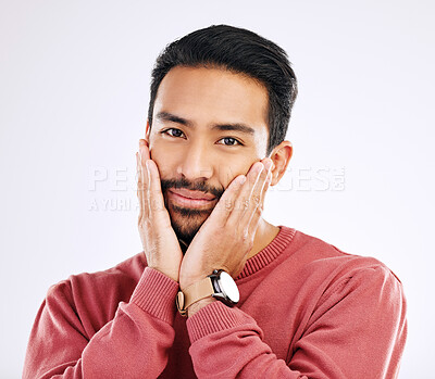 Buy stock photo Portrait, shy and in love with a man in studio isolated on a white background while touching his cheeks. Face, coy and cute with a handsome young indian male feeling special on valentines day