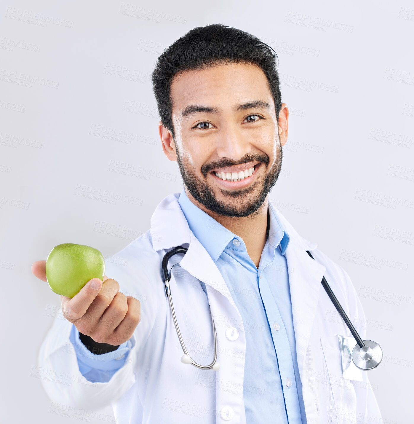 Buy stock photo Doctor, man and apple in portrait, happy with health and nutritionist isolated on studio background. Medical professional, male physician with smile and healthcare, promote healthy diet and nutrition