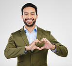 Portrait, heart and hand gesture with a business man in studio on a gray background for health or love. Hands, emoji and shape with a happy male employee showing a symbol or sign of affection