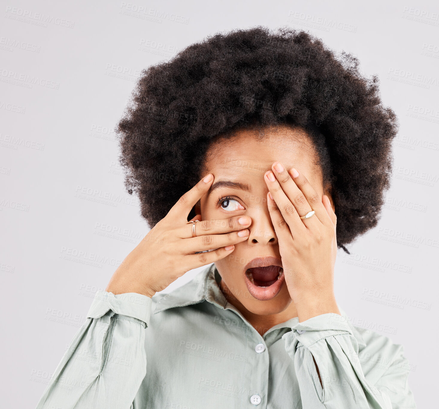 Buy stock photo Shock, scared and a black woman looking through hands isolated on a white background in a studio. Wow, scary and an African girl covering eyes with a hand for a horror, bad surprise or frightened