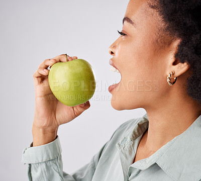 Buy stock photo Apple, health and black woman in studio eating for nutrition, wellness and healthy snack. Food, diet and face profile of girl eat green fruit for detox, vitamins and weight loss on white background