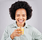 Portrait, smile and orange juice with a laughing woman in studio on a gray background for health or vitamin c. Face, drink and glass with a happy young female drinking a fresh beverage for nutrition