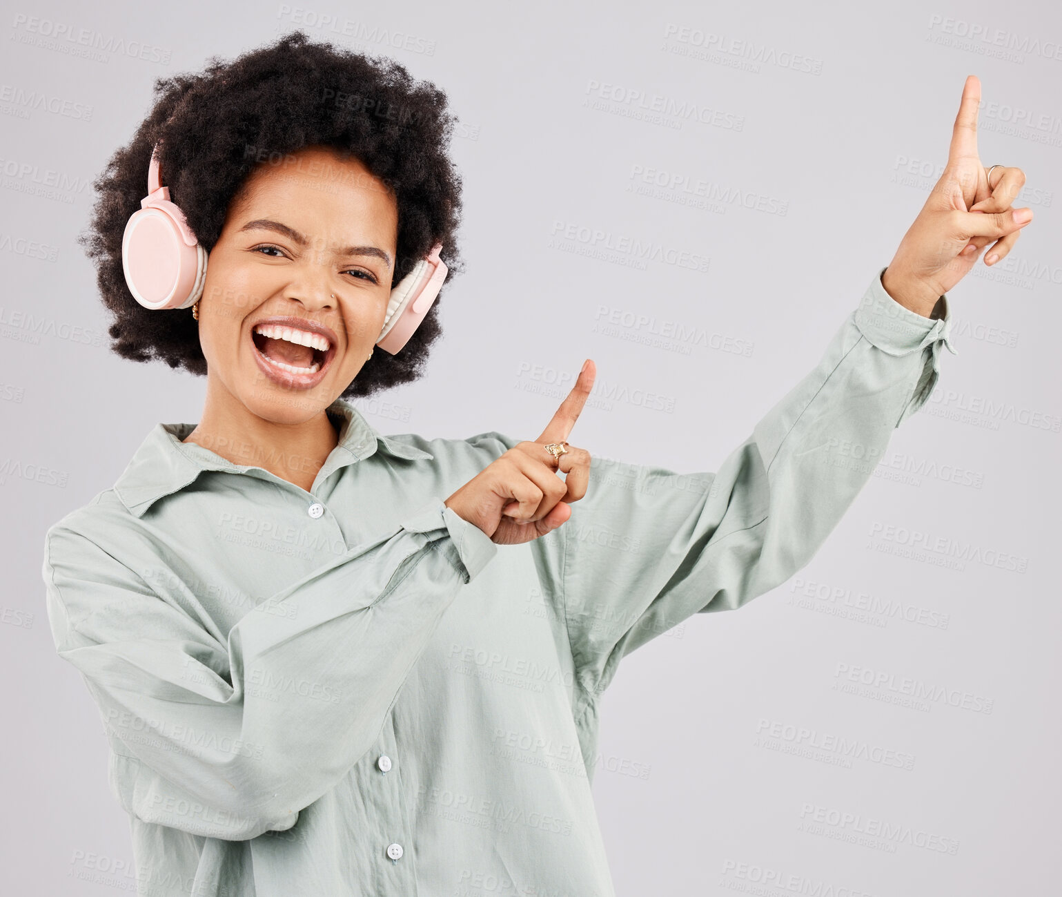 Buy stock photo Portrait, music headphones and black woman pointing up in studio isolated on a white background mockup or advertising space. Singer, radio and happiness of person listening to audio, sound or podcast