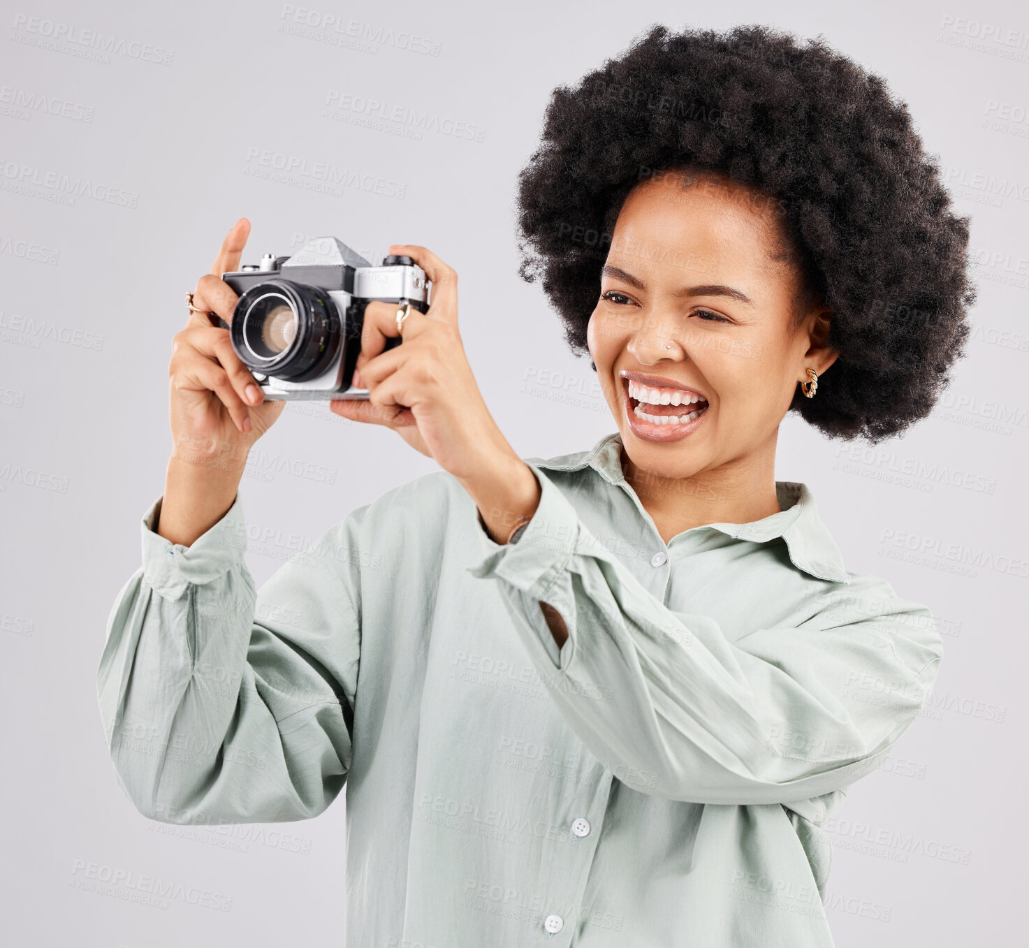 Buy stock photo Laughing, camera photographer and black woman in studio isolated on a white background. Photography, professional and funny person or female ready to start filming, photoshoot or taking picture.