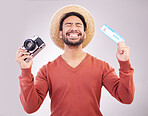 Ticket, camera and excited man in studio with paperwork for holiday, adventure and fun hat on white background. Smile, travel and happy person with boarding pass for vacation, journey and happiness.