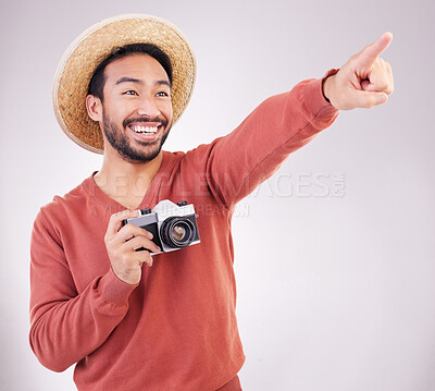 Buy stock photo Travel, camera and excited man pointing at view in studio on holiday with adventure, fun and white background. Smile, discovery and happy tourist on vacation, photographer on journey with happiness.