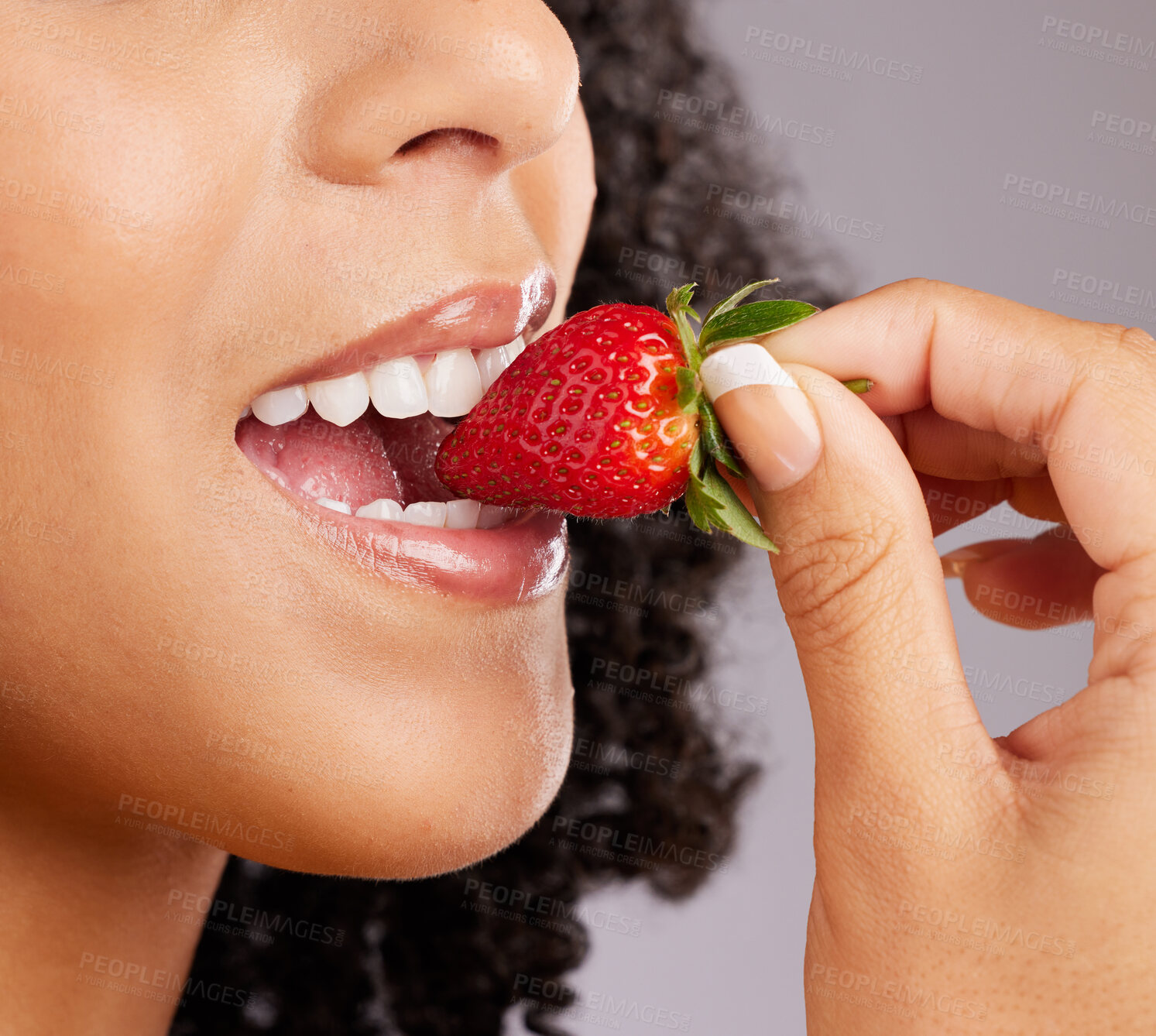 Buy stock photo Woman, mouth and eating strawberry for natural nutrition, dieting or healthy food against a gray studio background. Closeup of female lips enjoying tasty organic fruit for health, diet or wellness