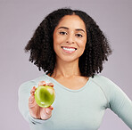 Happy woman, portrait smile and apple for diet, natural nutrition or vitamins against a gray studio background. Female model smiling and holding organic fruit for healthy dieting, food or wellness