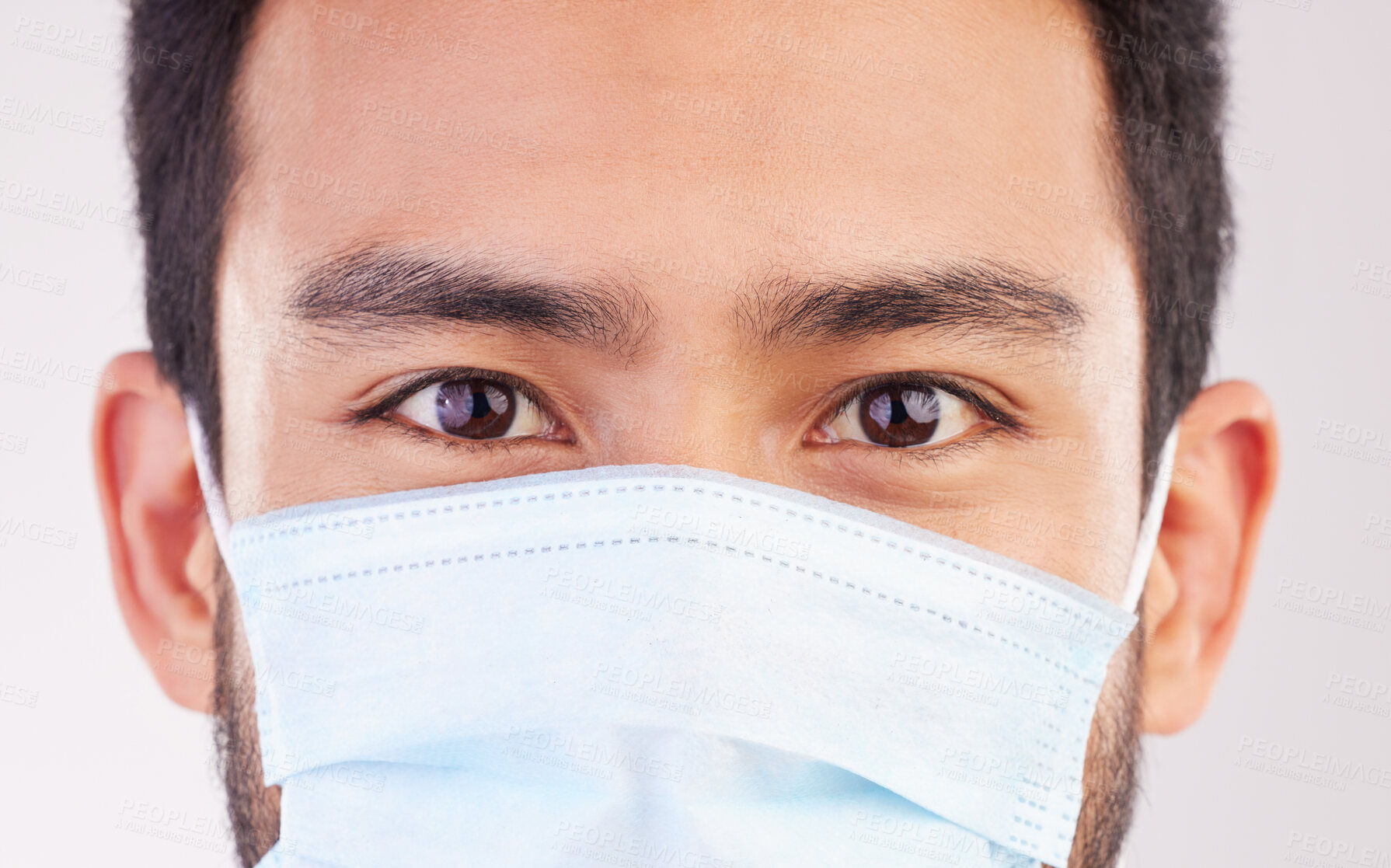 Buy stock photo Doctor, portrait and man with mask for covid, compliance and safety in studio closeup. Facemask, prevention and eyes of male health expert at a clinic for help, treatment and healthcare control 