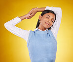 Relax, stretching and a woman on a yellow background in studio for peace, quiet or free time. Freedom, sleepy or lifestyle and an attractive young female posing with her eyes closed for a stretch