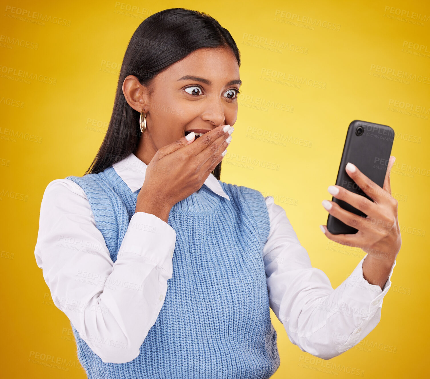 Buy stock photo Wow, surprise and woman with phone in studio space reading text or email on yellow background. Technology, communication and good news, happy Indian girl with social media gossip or online content.