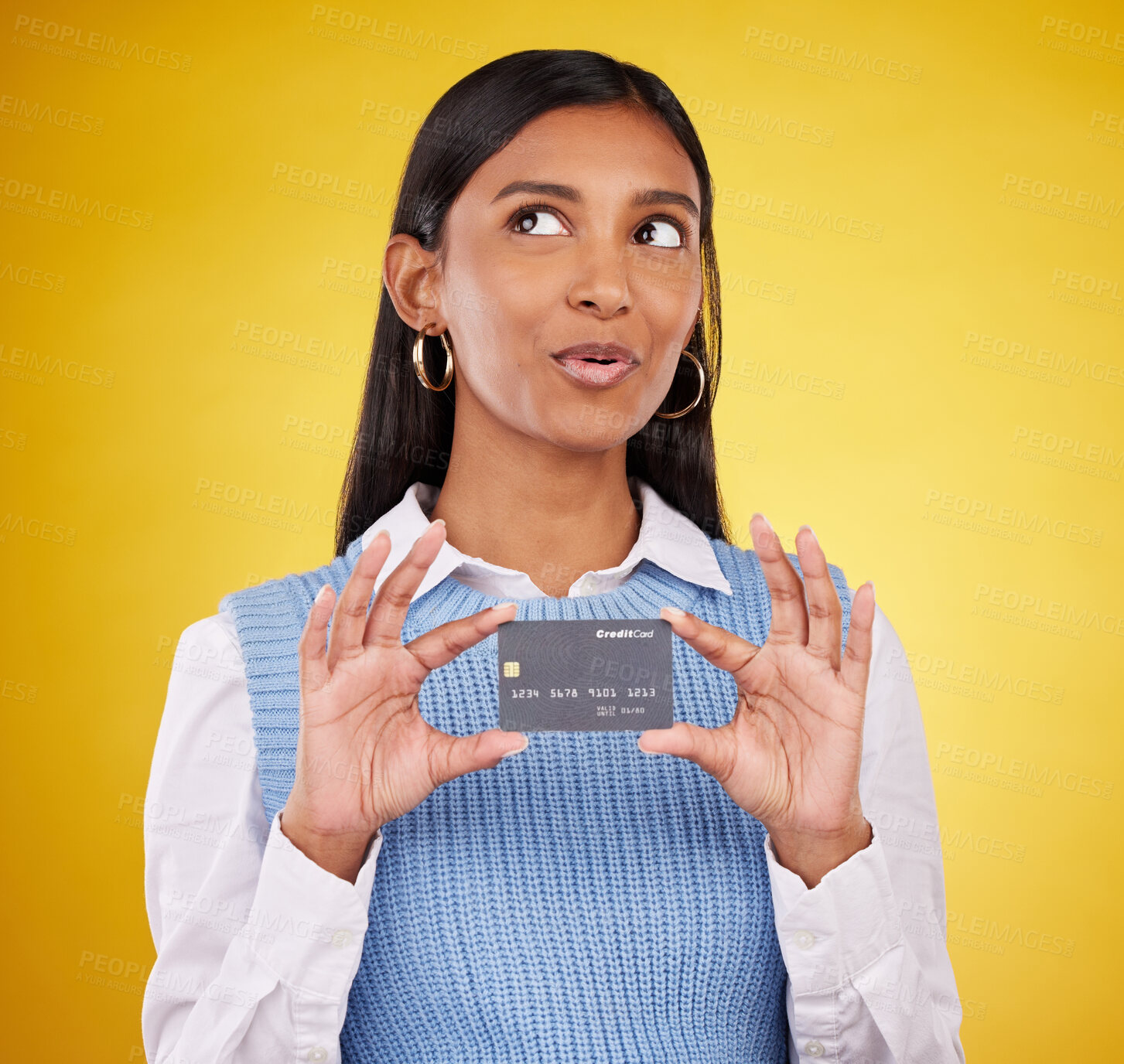 Buy stock photo Credit card, thinking and Indian woman on yellow background for bank, investment and payment in studio. Banking mockup, finance and happy girl with plastic for budget, commerce and discount purchase