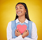Satisfaction, paper and heart with woman in studio for love, support and romance. Valentines day, kindness and date with female and symbol mockup on yellow background for health, happiness and hope