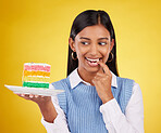Birthday, diet and woman with cake in studio for happy celebration or party on yellow background. Happiness, excited gen z model with rainbow dessert on plate to celebrate milestone or achievement.