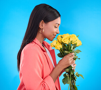 Buy stock photo Smell, flowers and bouquet with woman in studio for gift, satisfaction and spring. Relax, happy and floral present with female and roses isolated on blue background for aroma, natural and products