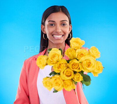 Buy stock photo Happy, gift and a portrait of a woman with flowers isolated on a blue background in a studio. Smile, holding and a girl giving a floral bouquet as a present, showing a flower and fresh roses
