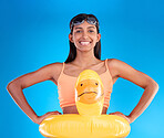 Happy, pool float and portrait of woman in studio for summer, swimming and holiday. Smile, happiness and beach vacation with female and duck inflatable on blue background safety, playful and funny